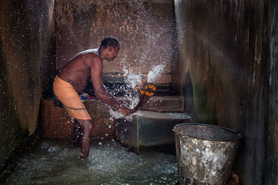 Young man splashing water