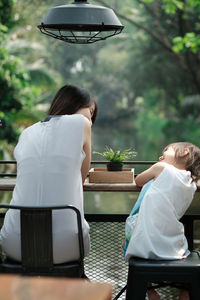 Rear view of women sitting on table