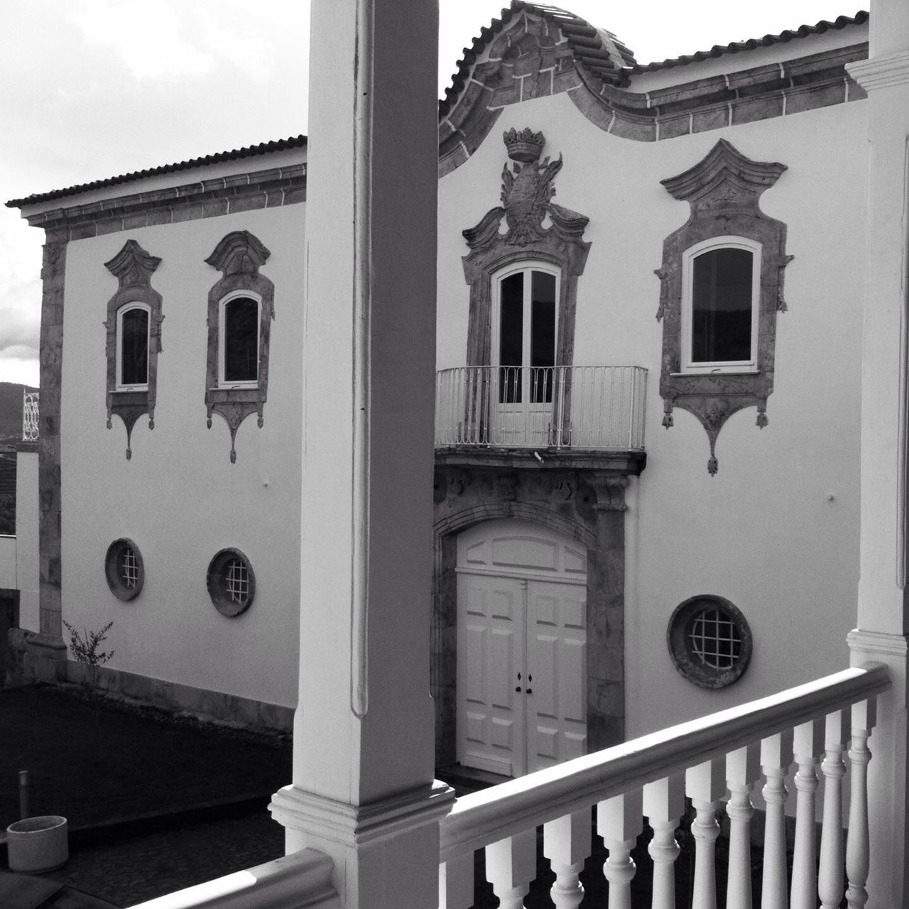 architecture, building exterior, built structure, window, low angle view, building, railing, door, day, facade, arch, entrance, outdoors, history, no people, city, balcony, architectural column, sky, gate