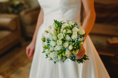 Midsection of woman holding flower bouquet