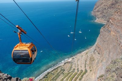 High angle view of cablecar in front of sea and cliff