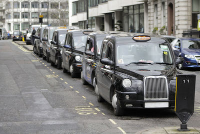 Cars parked on road by buildings in city