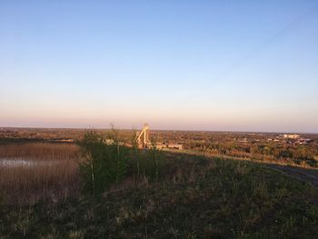 Scenic view of field against clear sky during sunset