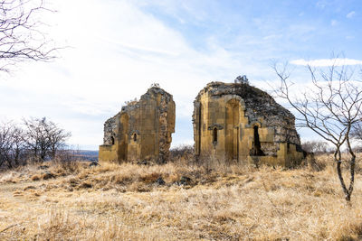 Abandoned built structure on field against sky