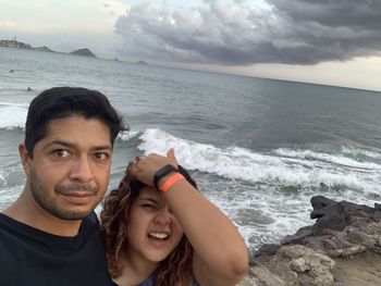 Portrait of smiling woman on beach against sky