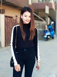 Portrait of young woman standing outdoors