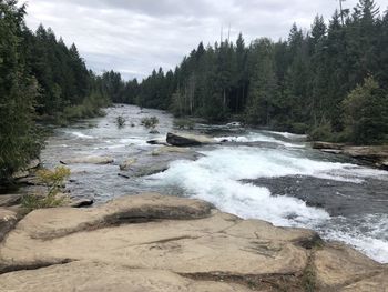 Scenic view of waterfall against sky