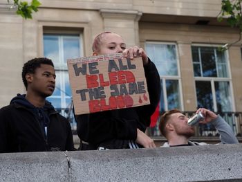 Young man holding camera in city