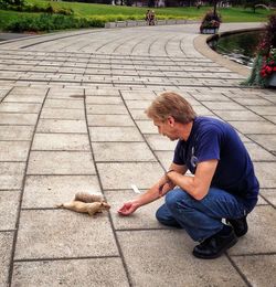 Full length of man feeding a squirrel