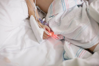 Midsection of woman lying on bed