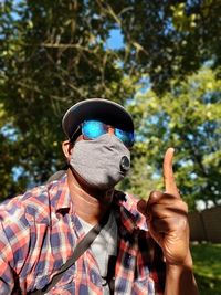 Portrait of man wearing mask against trees