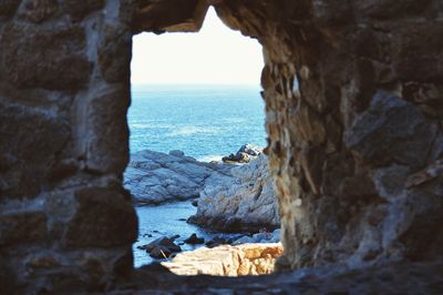 Rocks by sea against sky