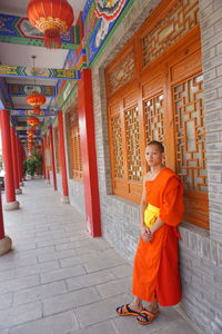 Full length of woman standing in temple outside building