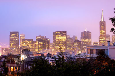 Illuminated buildings in city against sky