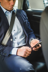 Mature businessman using mobile phone while sitting in car