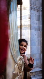 Young woman looking through window