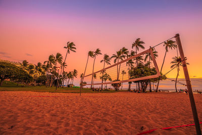 Volleyball net at beach against sky during sunset