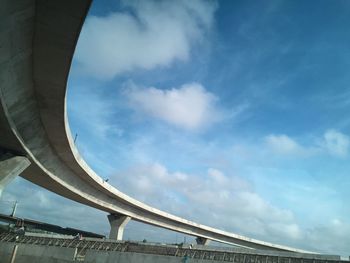 Low angle view of bridge against cloudy sky