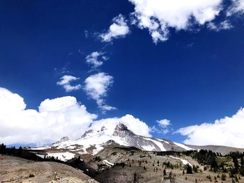 Scenic view of snowcapped mountains against blue sky