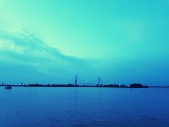 Bridge over sea against blue sky