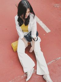 High angle view of young woman sitting outdoors