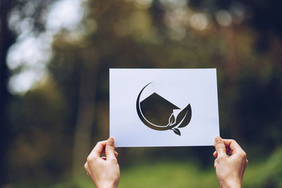 Midsection of person holding paper against blurred background