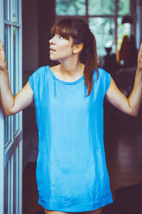 Young woman standing against wall