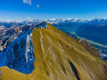 Scenic view of snowcapped mountains against blue sky