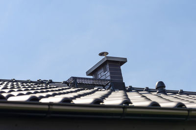 The roof of a single-family house covered with a new ceramic tile in anthracite, system chimney