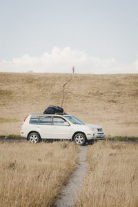 Car on road by land against sky