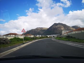 Road by mountain seen through car windshield