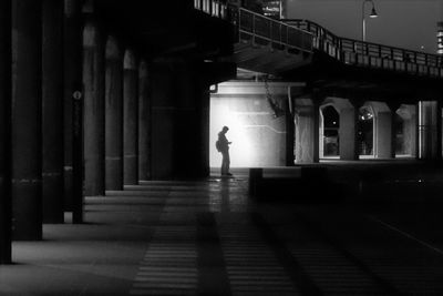 Woman walking in illuminated bridge