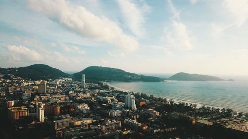 High angle view of city by sea against sky