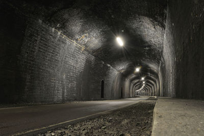 Empty road in illuminated tunnel