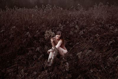 Portrait of young woman sitting on grassy field