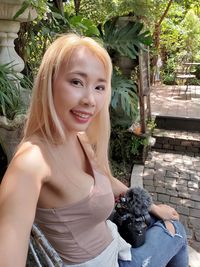 Portrait of a smiling young woman sitting outdoors