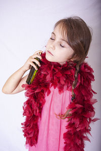 Girl holding red flowers against white background