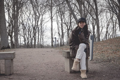 Full length portrait of woman sitting in park