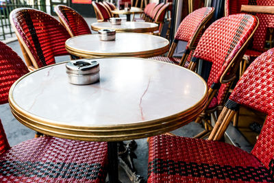 Close-up of empty tables and chairs at sidewalk cafe