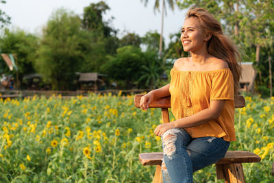 Smiling young woman with yellow flowers