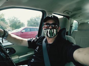 Portrait of young man sitting in car