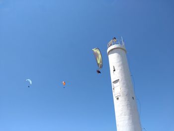 Low angle view of airshow against clear blue sky