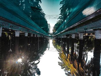 Bridge over canal in city against sky