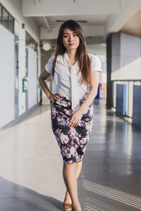 Portrait of young woman walking in corridor