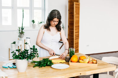 Woman preparing food on table at home