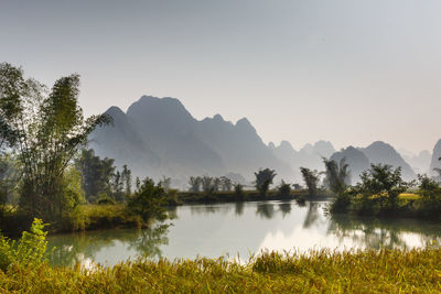 Scenic view of lake by trees against sky