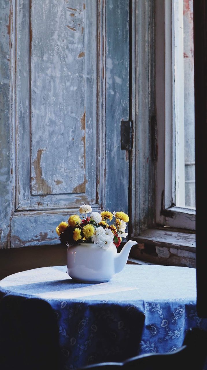 FLOWER VASE ON TABLE BY WINDOW