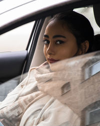 Portrait of young woman in car