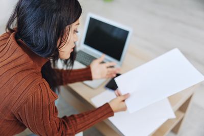 Rear view of woman using laptop on table