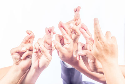 Midsection of woman holding hands against white background